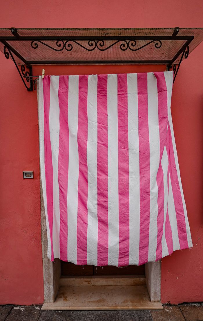 gallery-01 Pink and white striped curtain covering a small entrance door.