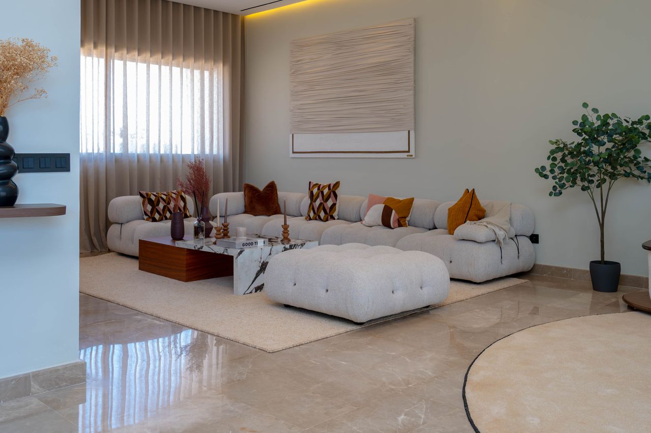 services-05 Stylish living room featuring a modern sofa, decorative cushions, and a lush plant, creating a cozy atmosphere.