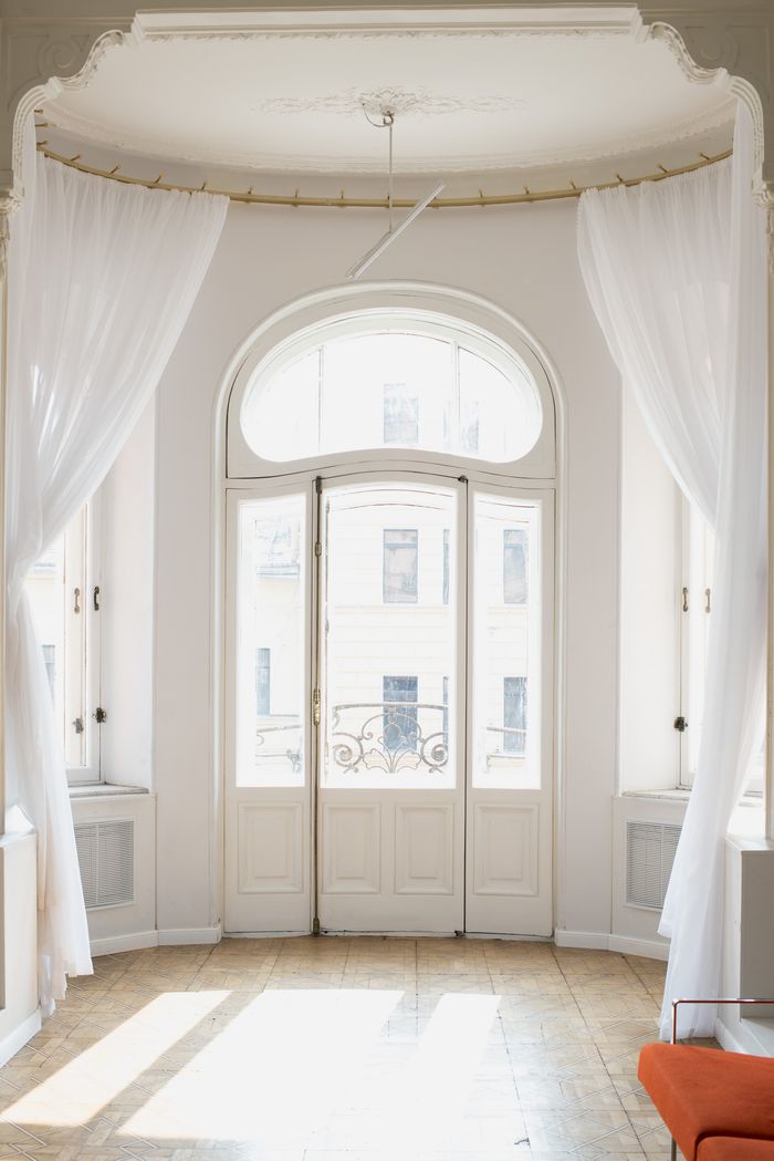 cta-02 Bright and classic indoor view featuring elegant white French doors adorned with sheer white curtains.