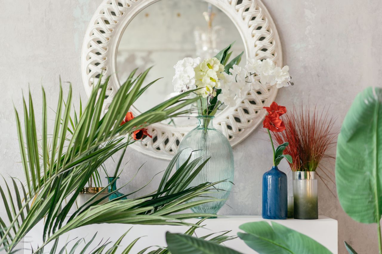 gallery-04 Stylish interior featuring a floral arrangement with vibrant colors and a decorative mirror.